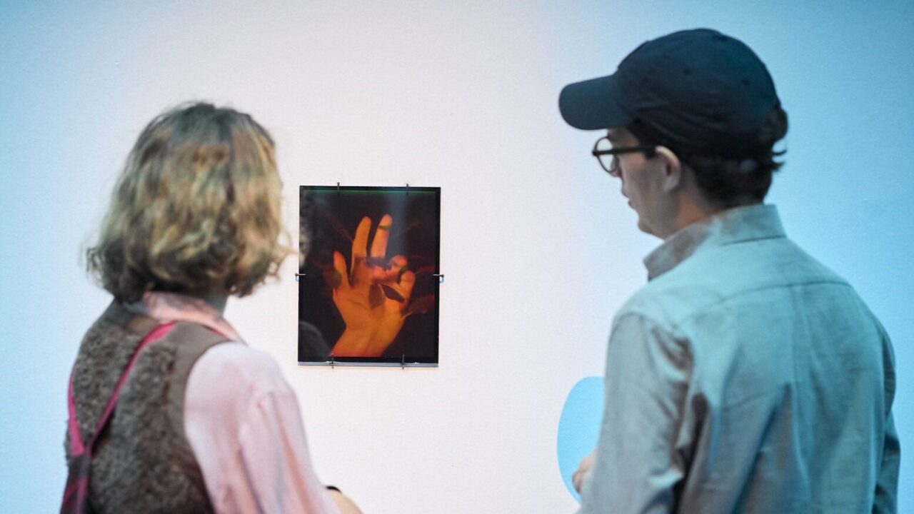 dues peronses miren un holograma a la paret