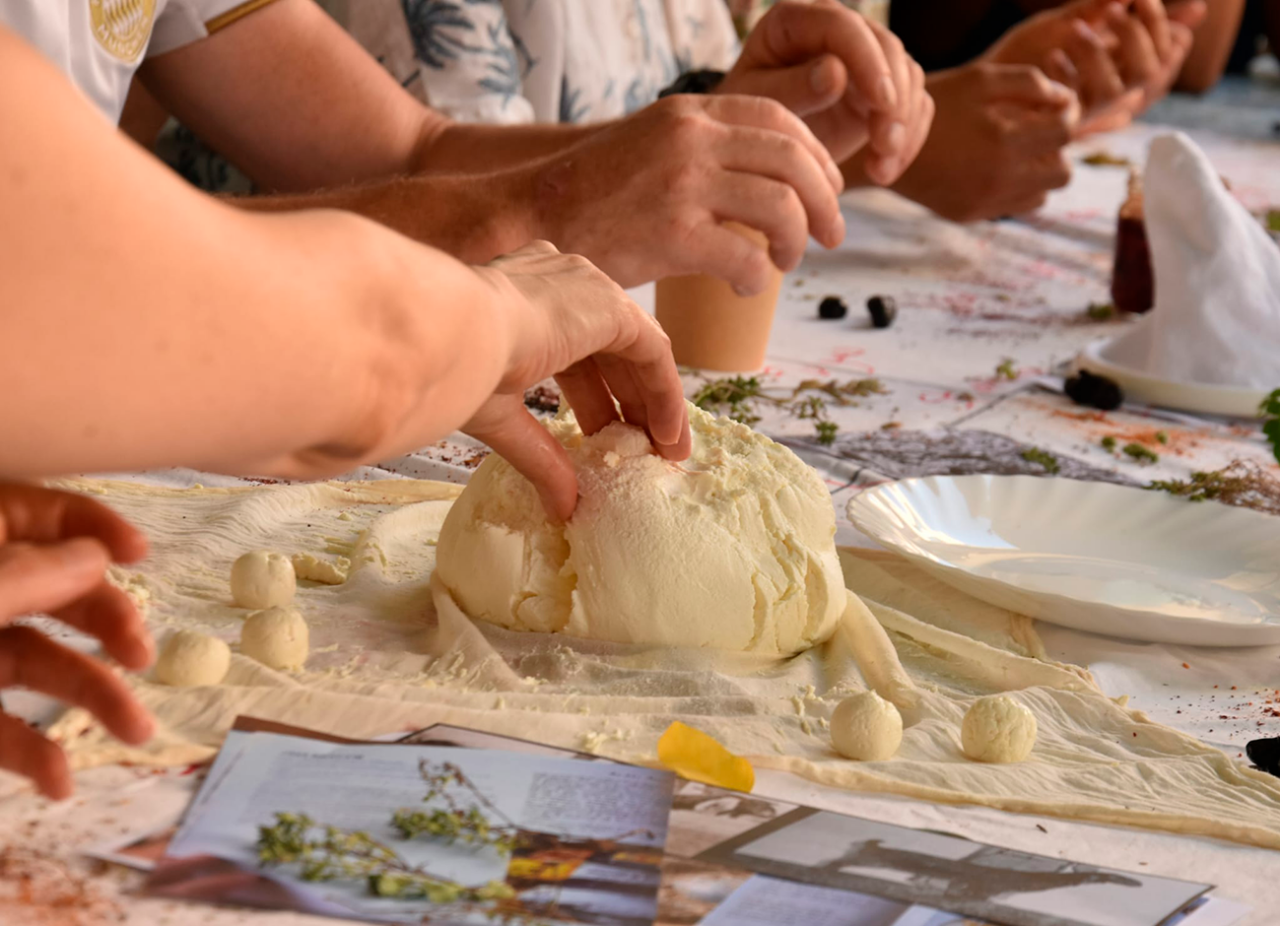Personas elaborando queso fresco en un taller colectivo.